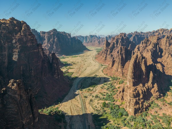 An aerial shot of Wadi Al-Disa in Tabuk, showing the mountains during the day, Saudi valleys, and nature in Saudi Arabia.