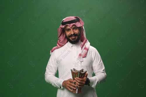 بورتريه رجل سعودي يرتدي الزي السعودي التقليدي يحمل المبخرة