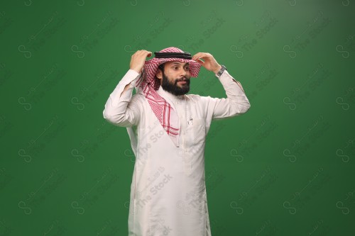 بورتريه رجل سعودي يرتدي الزي الرسمي التقليدي على خلفية خضراء يقوم بعمل اشارات بيديه وهو مبتسم ، حزين، غاضب، صور تذكارية ، توثيق لحظة سعيدة