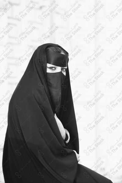 black and white shot of a Saudi woman wearing the traditional Saudi dress representing the folklore, the foundation day, and the Saudi culture