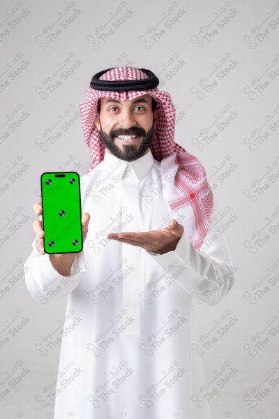 Portrait of a Saudi man holding a phone, pointing at the phone and making different expressions - green screen