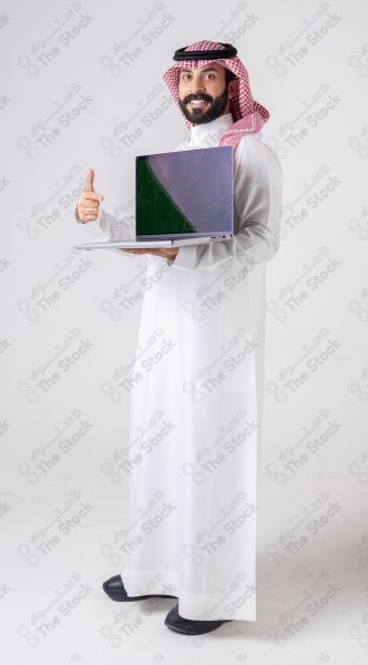 Portrait of a Saudi man holding a laptop, pointing at the laptop and making different expressions - green screen