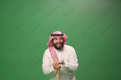 بورتريه رجل سعودي يرتدي الزي السعودي التقليدي يتكئ على العصا أثناء أداء رقصة المزمار الحجازية