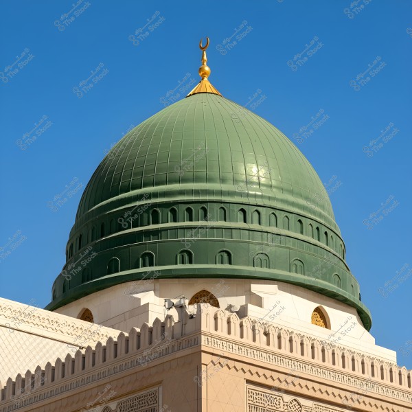 A large and famous green dome sits atop a building adorned with Islamic architectural details. The dome features a golden crescent on top, with a clear blue sky in the background.