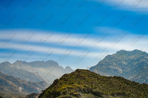 لقطة لسلسلة من الجبال الصخرية الشاهقة في الهدا بالطائف ، وتظهر السماء ملبدة بالغيوم وقت النهار، مرتفعات الجبال ، جبال الطائف  ، سلسلة جبلية