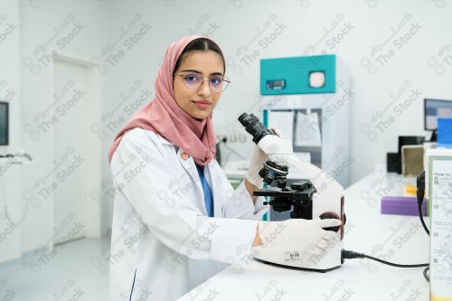 Saudi doctor in a hospital works in a laboratory, a medical team uses a microscope to examine a blood sample, and works in the field of health, providing medical consultations and medical health services.