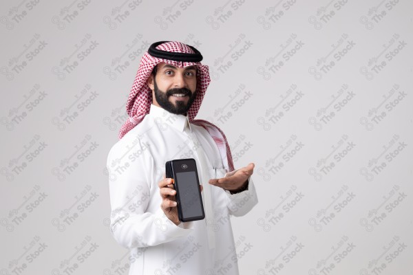 Portrait of a Saudi man holding an automatic payment device and making different expressions