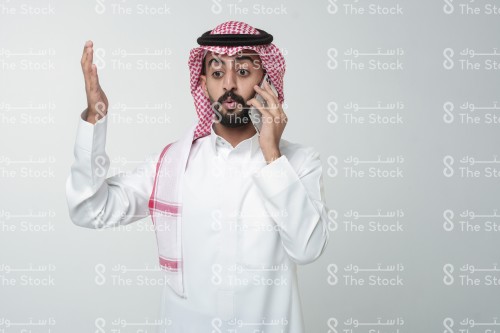 رجل سعودي يقوم بإشارات وهو يتحدث على الهاتف