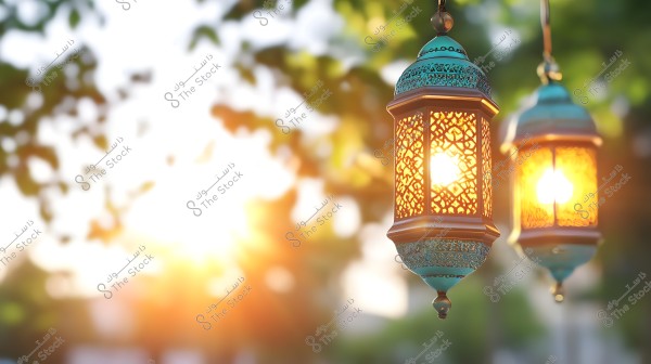 Two traditional lanterns illuminated with warm lights hanging in the air amid a blurred natural background. The lanterns showcase intricate decorative patterns and geometric designs. The warm yellow lighting creates a cozy and cheerful atmosphere, with the background featuring green and white colors and scattered sunlight throughout the scene.