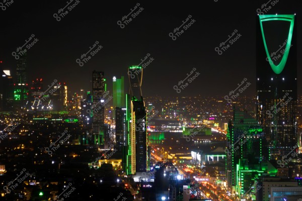صورة لمدينة الرياض بالمملكة العربية السعودية ليلًا حيث تظهر مباني المدينة والأضواء الخضراء المميزة لناطحات السحاب, بما في ذلك برج المملكة الشهير بإضاءته الخضراء البارزة في الأفق.