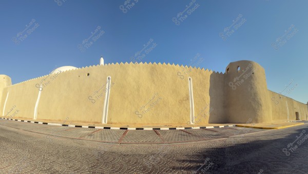 منظر لجدار حصن تقليدي مع قبب بيضاء وخلفية سماء صافية.