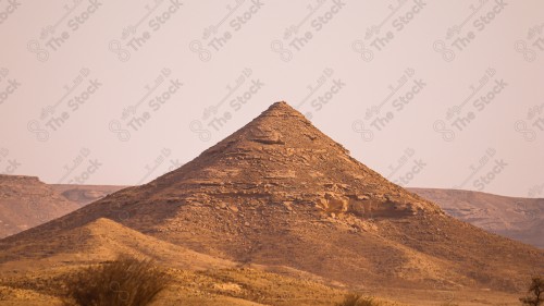 لقطة جوية لسلسلة جبال طويق في منطقة نجد وتظهر السماء ملبدة بالغيوم وقت النهار، سلسلة من الجبال الصخرية، حافة العالم.