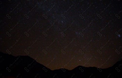 An aesthetic picture of the sky and twinkling stars in the middle of the Saudi desert at night, beautiful landscapes.