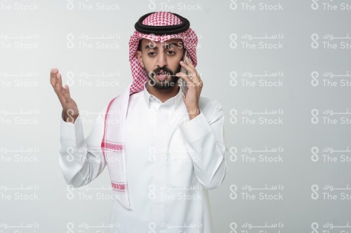 رجل سعودي يقوم بإشارات وهو يتحدث على الهاتف