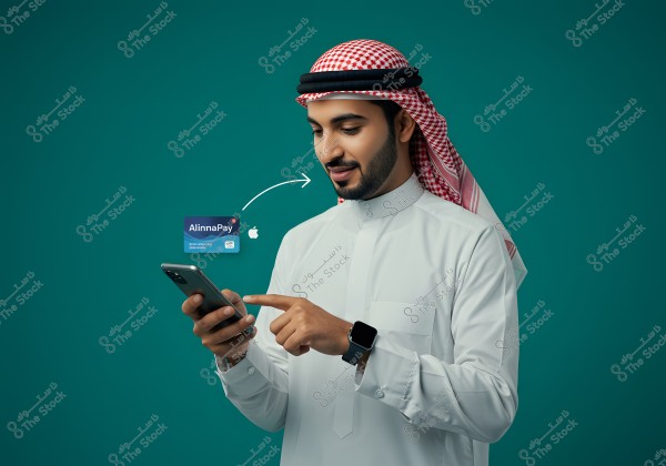 An image of a man wearing a white thobe and a red and white ghutra, suggesting he may be from Saudi Arabia or the Gulf region. The man is using a smartphone and appears to be making an electronic payment using the \"AlinnaPay\" service, with the service logo and Apple logo visible beside him.