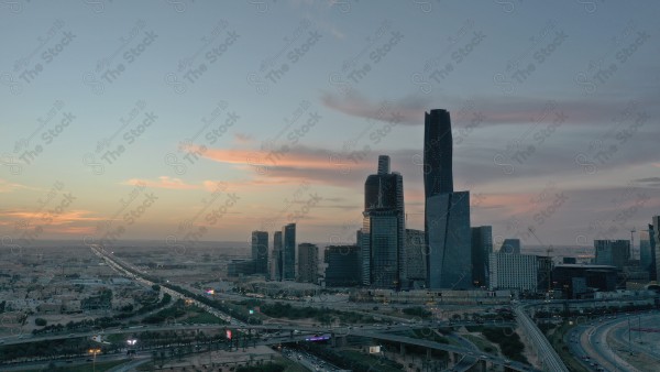 لقطة جوية للأبراج مركز الملك عبدالله المالي في العاصمة الرياض وتظهر السماء غائمة اثناء الغروب، حركة المرور في مدينة الرياض