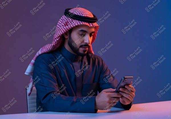 A portrait of a man wearing traditional Saudi attire in blue, with a red and white checkered ghutra. He is seated on a chair and holding a smartphone in his hand, set against a calm background of blue and pink tones.