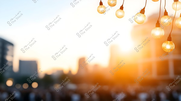 Image of a city sunset with illuminated string lights in the foreground. The background features a blurred view of buildings and a sky transitioning from blue to orange with the sun\'s glow.