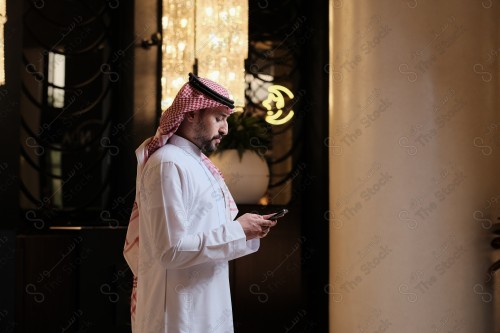 شاب سعودي في استقبال فندق ويقوم بتفاعلات متعددة ، ويظهر بيده حقيبة السفر