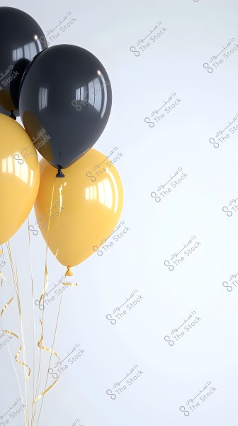 An image showing a cluster of balloons, three in black and two in yellow, floating in the air with thin golden strings. The background is a simple white, highlighting the colors of the balloons.