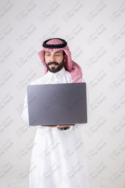 Portrait of a Saudi man holding a laptop and making different expressions, customer service, and communication.