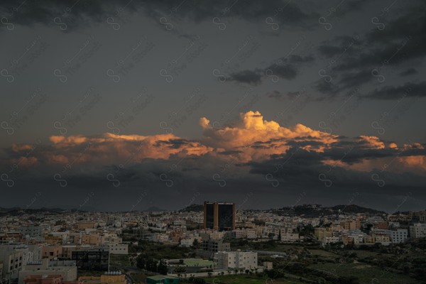 لقطة جوية  لمدينة أبها وسط الطبيعة الخضراء أثناء غروب الشمس  وتظهر السماء مليئة بالسحب الركامية ، الطبيعة في السعودية