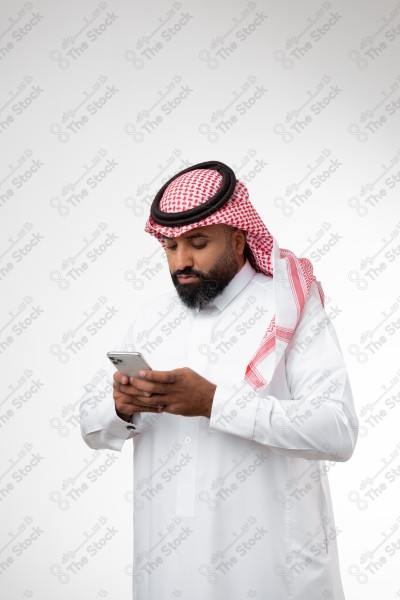 Portrait of a Saudi man holding a phone and making different expressions, white background