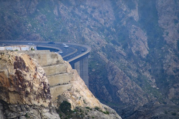 لقطة جمالية لطريق في جبال الطائف في السعودية وتظهر السماء صافية نهارًا، مرتفعات الجبال ، سلسلة من الجبال