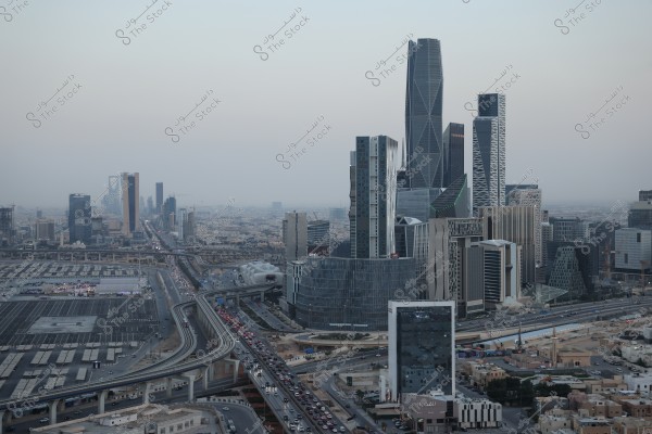 Image of Riyadh city in Saudi Arabia, featuring modern skyscrapers and streets filled with cars. The buildings showcase modern and innovative architectural designs, including the prominent King Abdullah Financial District in the image. Roads and bridges are busy with the city's usual traffic.