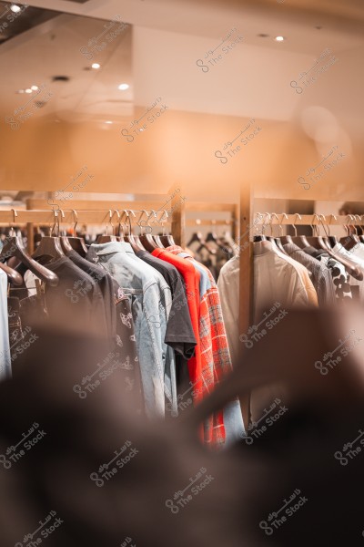 Clothes displayed on wooden hangers in a clothing store.