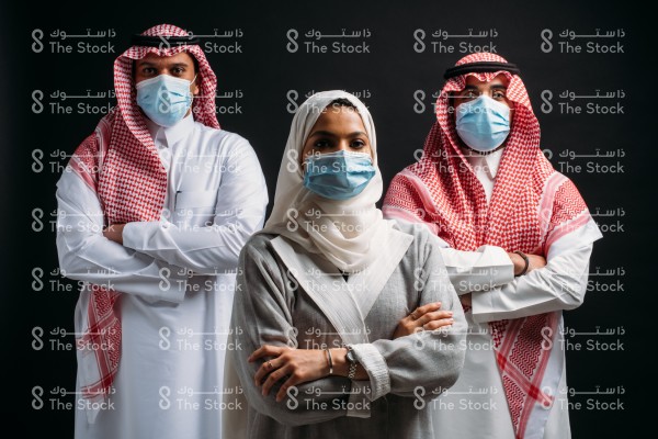 مجموعة أشخاص السعوديين يلتزمون بالكمامة على خلفية سوداء