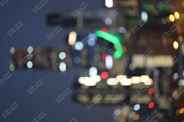 An image showing a cityscape at night with blurred colorful building lights. The lights are scattered with red, green, white, and blue spots, giving an impression of a vibrant night scene.