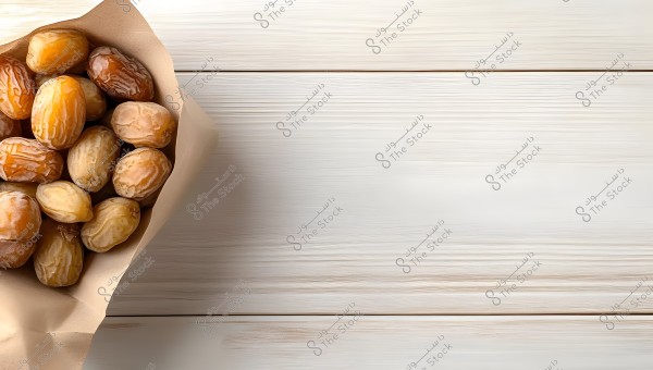 Image of several dates placed inside a brown paper wrap, on a white wooden surface. The dates look shiny and fresh, with colors ranging from dark golden to light brown.