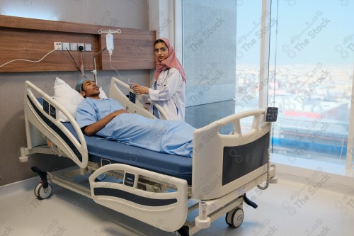 A Saudi female doctor wears a medical uniform and is examining and applying a nutrient solution, medicine and health care