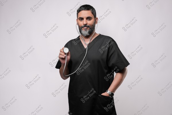 طبيب يرتدي ملابس طبية سوداء ويستخدم سماعة طبية.
