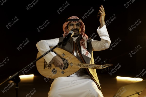 عازف يعزف على العود بينما يغني مرتديًا الزي التقليدي.