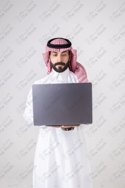 Portrait of a Saudi man holding a laptop and making different expressions, customer service, and communication.