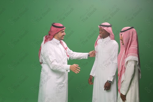 رجل سعودي يرتدي الزي السعودي التقليدي يستقبل ضيوفه بحفاوة في إحدى المناسبات