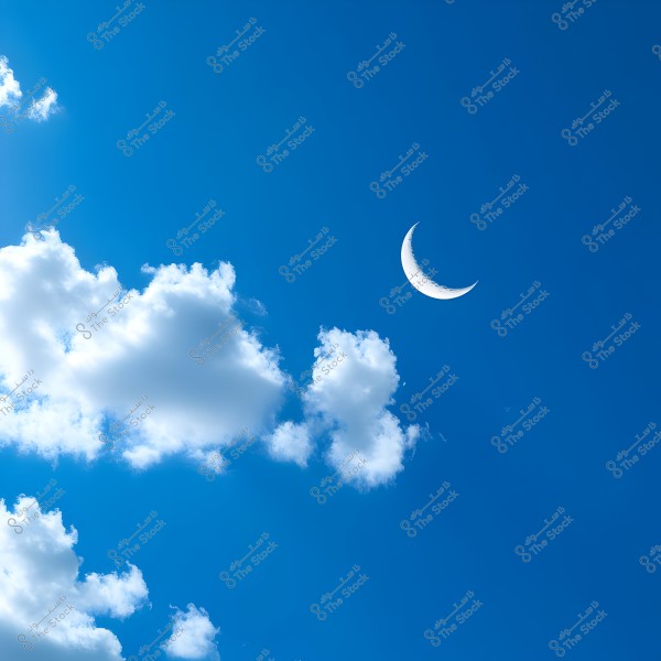 An image of a clear blue sky on a sunny day with soft white clouds scattered across the scene. A white crescent moon is visible on the right side of the image, contrasting beautifully with the blue of the sky.