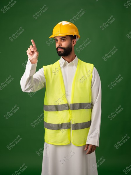 رجل يرتدي سترة أمان صفراء وخوذة واقية, يشير بإصبعه في اتجاه ما.