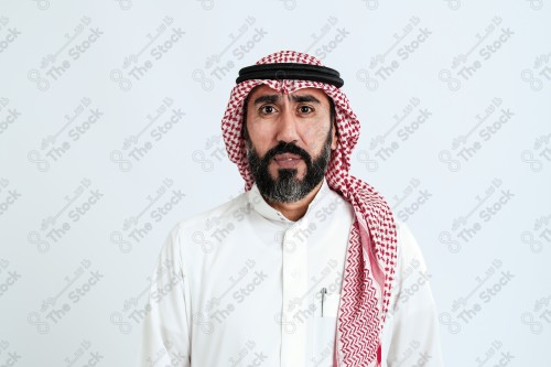 بورتريه رجل سعودي كبير بالسن يرتدي الزي الرسمي التقليدي على خلفية بيضاء يقوم بعمل اشارات بيديه وهو مبتسم ، حزين، غاضب، صور تذكارية ، توثيق لحظة سعيدة.