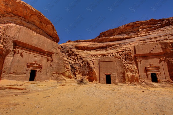 لقطة لجبل صخري في مدينه العلا والسماء تبدوا صافية نهارًا، سلسلة من الجبال الصخرية، تكوين صخري