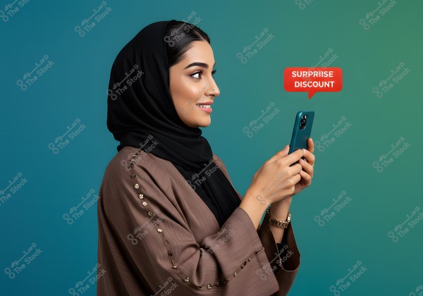 An image of a woman wearing a black hijab and a brown abaya adorned with golden buttons, holding a mobile phone in her hands. The woman is smiling at the screen, with a red speech bubble beside her containing the words \"SURPRISE DISCOUNT.\" The background is a gradient blue.