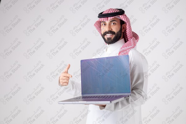 Portrait of a Saudi man holding a laptop, pointing at the laptop and making different expressions - green screen