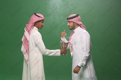 رجل سعودي يرتدي الزي السعودي التقليدي يقدم المبخره لضيفه في أحد المناسبات