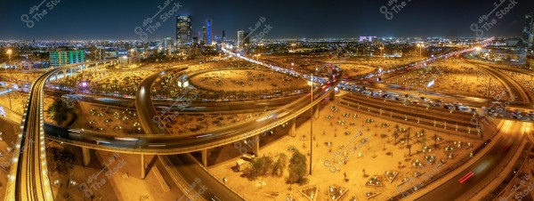** A nighttime view of a large city showcasing a complex network of highways and bridges, with moving car lights and urban lighting in the background. Tall buildings adorn the skyline in the evening, reflecting the city\'s urban and architectural growth.\r\n\r\n**