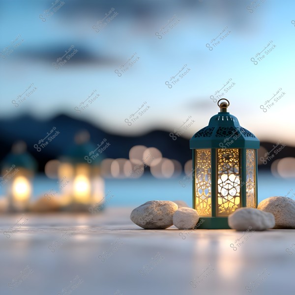 A decorative metallic lantern is lit, placed next to some small stones, emitting warm light that creates a serene ambiance. In the background, there is a blurred natural scene of mountains and a dusky blue sky, adding a calm and spiritual atmosphere to the image.