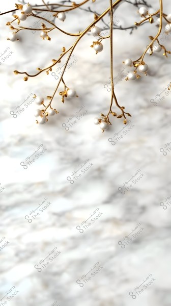 Image showing thin golden branches adorned with small white spherical ornaments. The branch is prominently displayed against a blurred light gray background, giving an artistic and minimalistic impression.