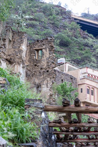 An ancient building built of stones in the middle of a group of windows surrounded by white paint while the sky looks cloudy during sunset, Rijal Almaa Heritage Village in the Asir region