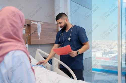 Saudi female doctor and paramedic in medical uniform and examining and applying nutritional solution, medicine and health care